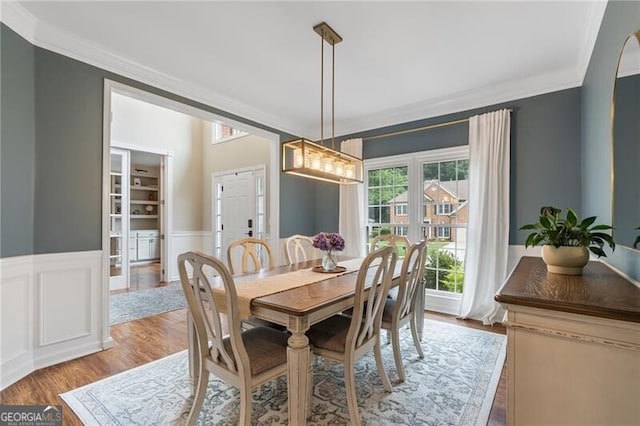 2772 Hillgrove Dr, Dacula, GA 30019 - dining area with crown molding, wood finished floors, wainscoting, and a decorative wall