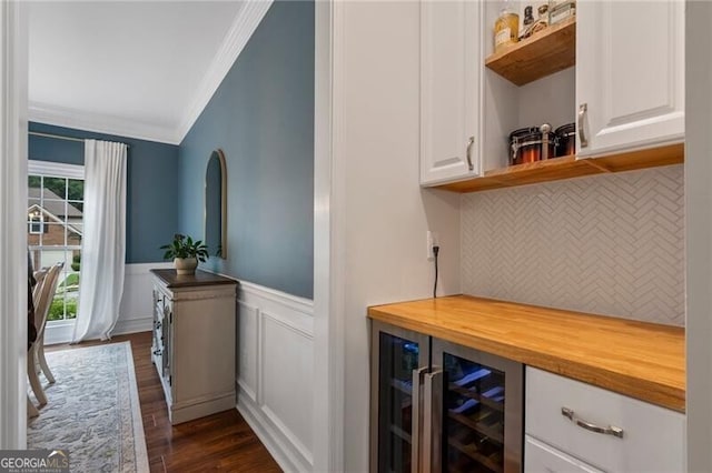2772 Hillgrove Dr, Dacula, GA 30019 - indoor dry bar featuring crown molding, dark wood finished floors, beverage cooler, decorative backsplash, and wainscoting