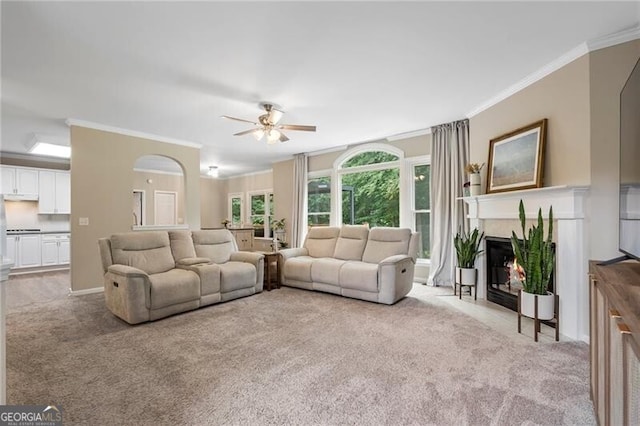 2772 Hillgrove Dr, Dacula, GA 30019 - living room with carpet flooring, ornamental molding, ceiling fan, a fireplace with flush hearth, and arched walkways
