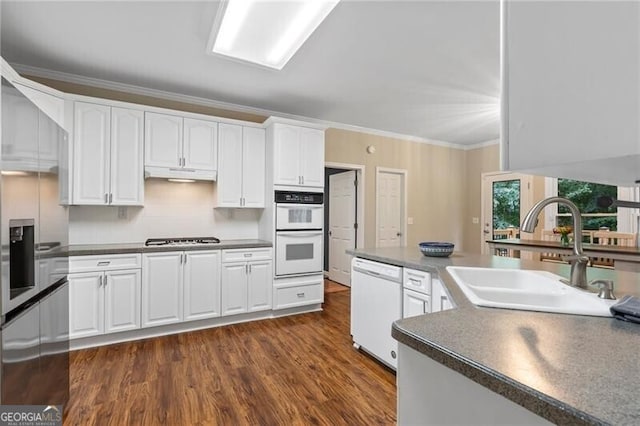 2772 Hillgrove Dr, Dacula, GA 30019 - kitchen featuring white appliances, under cabinet range hood, dark countertops, white cabinets, and dark wood-type flooring