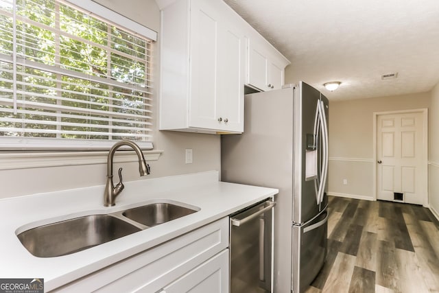 1421 Oak Knoll Dr NE, Conyers, GA 30012 - kitchen with appliances with stainless steel finishes, white cabinetry, light countertops, dark wood-style flooring, and a textured ceiling