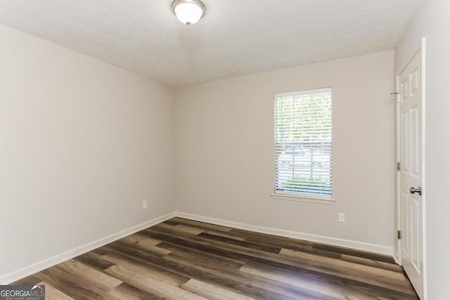 1421 Oak Knoll Dr NE, Conyers, GA 30012 - unfurnished room featuring dark wood finished floors and a textured ceiling