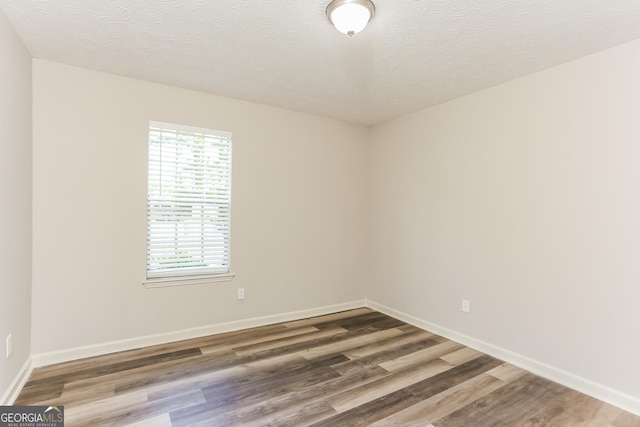 1421 Oak Knoll Dr NE, Conyers, GA 30012 - spare room featuring wood finished floors and a textured ceiling