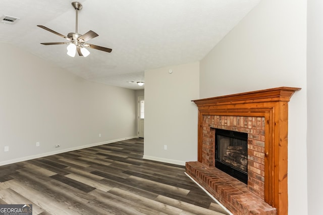1421 Oak Knoll Dr NE, Conyers, GA 30012 - unfurnished living room featuring a fireplace, a ceiling fan, dark wood-type flooring, lofted ceiling, and a textured ceiling