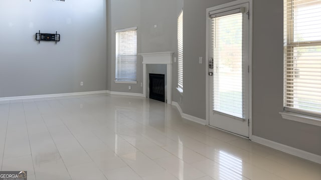 3368 Alhambra Cir, Hampton, GA 30228 - unfurnished living room featuring light tile patterned floors, a fireplace, and healthy amount of natural light