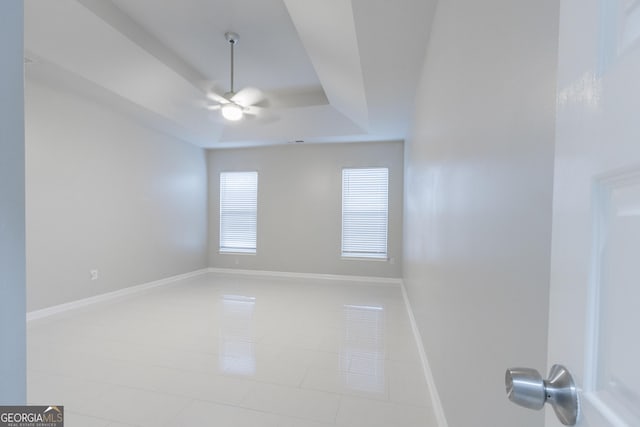 3368 Alhambra Cir, Hampton, GA 30228 - empty room featuring a ceiling fan, light tile patterned flooring, and a tray ceiling