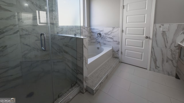 3368 Alhambra Cir, Hampton, GA 30228 - bathroom with tile walls, a garden tub, a marble finish shower, tile patterned floors, and wainscoting