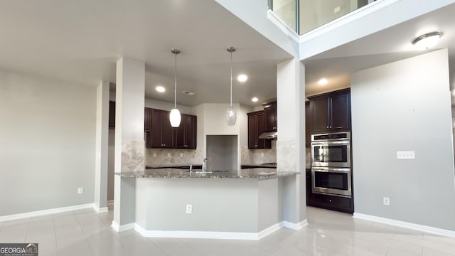 3368 Alhambra Cir, Hampton, GA 30228 - kitchen featuring stainless steel double oven, tasteful backsplash, light stone countertops, dark brown cabinets, and recessed lighting