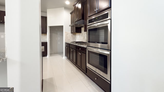 3368 Alhambra Cir, Hampton, GA 30228 - kitchen with stainless steel appliances, under cabinet range hood, backsplash, and dark brown cabinetry