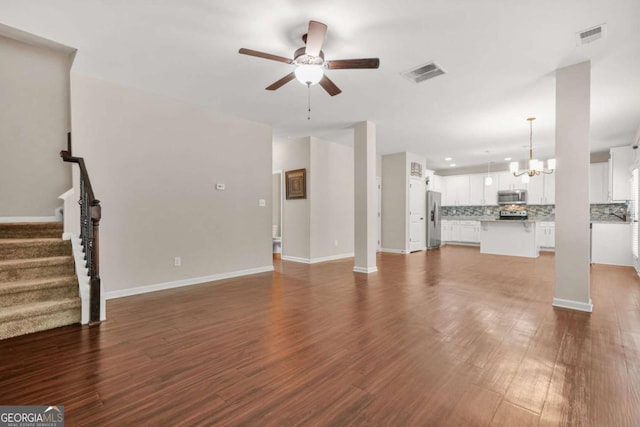255 Hamilton Dr, Newnan, GA 30263 - unfurnished living room with a ceiling fan, a chandelier, stairs, dark wood finished floors, and recessed lighting