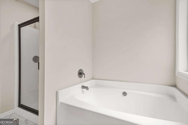 255 Hamilton Dr, Newnan, GA 30263 - bathroom featuring a garden tub, a stall shower, and marble look tiles