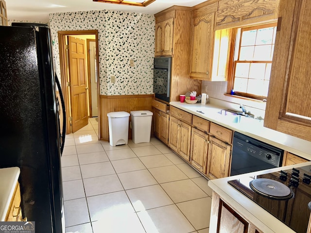 4494 Anderson Hwy, Hartwell, GA 30643 - kitchen featuring black appliances, a wainscoted wall, light countertops, wooden walls, and light tile patterned floors