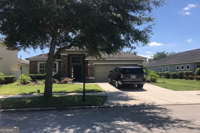 5785 Alamosa Cir, Jacksonville, FL 32258 - view of front of house featuring an attached garage, concrete driveway, a front yard, and stone siding