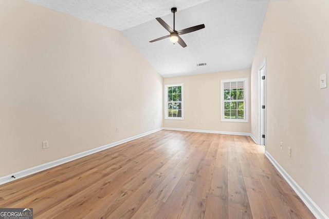 4210 Platinum Ct, Hoschton, GA 30548 - spare room featuring ceiling fan, light wood-type flooring, a textured ceiling, and vaulted ceiling