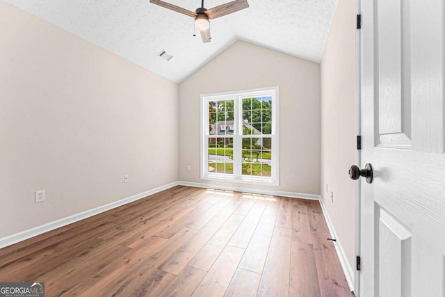 4210 Platinum Ct, Hoschton, GA 30548 - empty room with a ceiling fan, lofted ceiling, wood-type flooring, and a textured ceiling