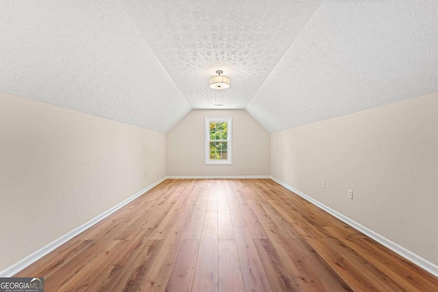 4210 Platinum Ct, Hoschton, GA 30548 - bonus room with a textured ceiling, hardwood / wood-style floors, and vaulted ceiling