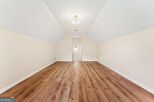 4210 Platinum Ct, Hoschton, GA 30548 - additional living space featuring a textured ceiling, wood finished floors, and vaulted ceiling