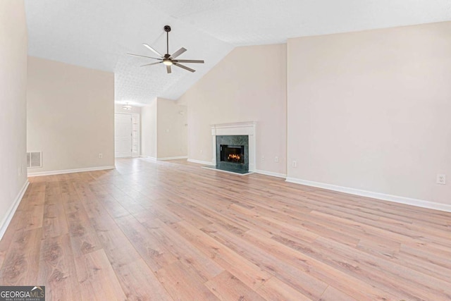 4210 Platinum Ct, Hoschton, GA 30548 - unfurnished living room with a ceiling fan, light wood-style floors, vaulted ceiling, and a fireplace