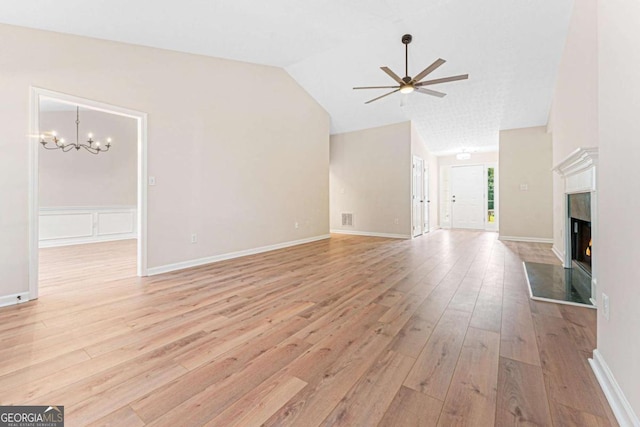 4210 Platinum Ct, Hoschton, GA 30548 - unfurnished living room with ceiling fan, light wood finished floors, vaulted ceiling, a chandelier, and a high end fireplace