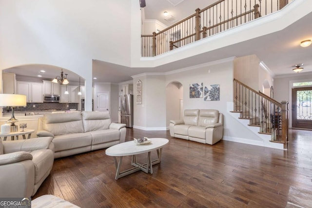 2307 Loughridge Dr, Buford, GA 30519 - living room with arched walkways, a high ceiling, a chandelier, dark wood finished floors, and stairs