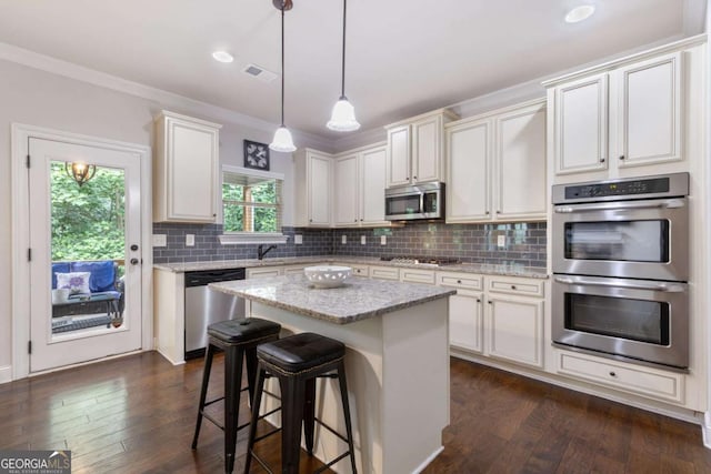 2307 Loughridge Dr, Buford, GA 30519 - kitchen featuring stainless steel appliances, light stone counters, decorative light fixtures, tasteful backsplash, and a center island