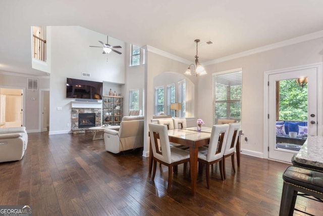 2307 Loughridge Dr, Buford, GA 30519 - dining area featuring dark wood-type flooring, a stone fireplace, ceiling fan, ornamental molding, and a chandelier