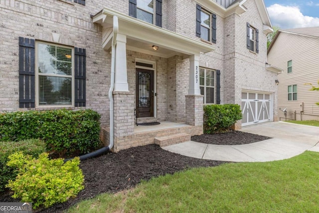 2307 Loughridge Dr, Buford, GA 30519 - property entrance with concrete driveway, a garage, and brick siding