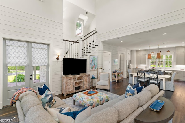 31 Frederica Oaks Ln, Saint Simons, GA 31522 - living room with dark wood finished floors, french doors, healthy amount of natural light, a towering ceiling, and stairway