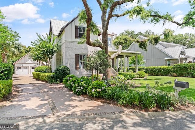 31 Frederica Oaks Ln, Saint Simons, GA 31522 - view of front of house featuring board and batten siding, a metal roof, and a front yard