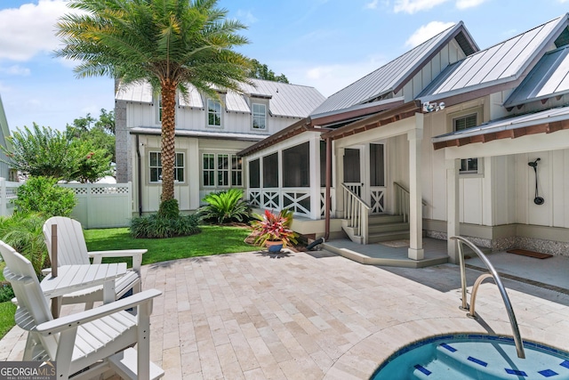 31 Frederica Oaks Ln, Saint Simons, GA 31522 - rear view of house featuring board and batten siding, a patio, a sunroom, and a metal roof