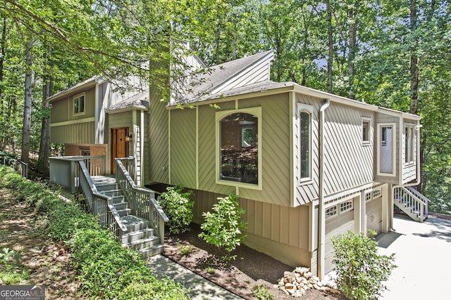970 Pine Grove Pointe Dr, Roswell, GA 30075 - view of front of home with stairway, driveway, a shingled roof, and view of wooded area