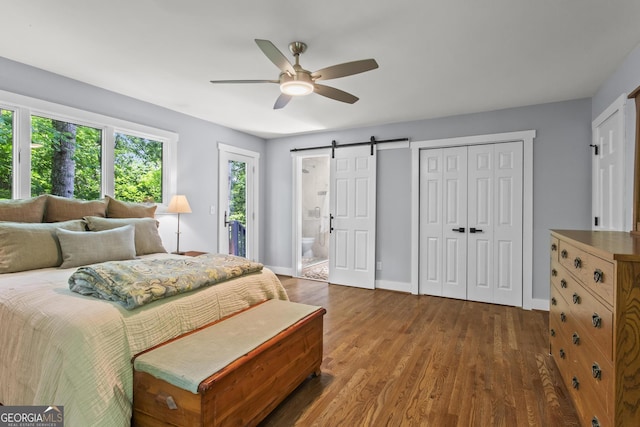 970 Pine Grove Pointe Dr, Roswell, GA 30075 - bedroom featuring a barn door, wood finished floors, a closet, a ceiling fan, and ensuite bathroom