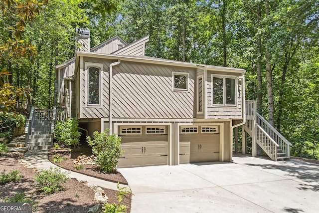 970 Pine Grove Pointe Dr, Roswell, GA 30075 - view of front of home with stairs, concrete driveway, an attached garage, and a chimney