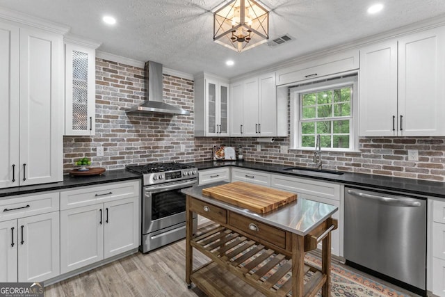 15 Stonewood Way, Sharpsburg, GA 30277 - kitchen with appliances with stainless steel finishes, wall chimney range hood, a chandelier, white cabinetry, and dark countertops
