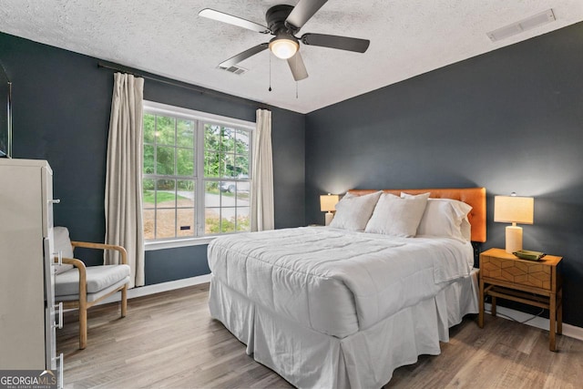 15 Stonewood Way, Sharpsburg, GA 30277 - bedroom with wood finished floors, a textured ceiling, and a ceiling fan
