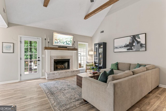 15 Stonewood Way, Sharpsburg, GA 30277 - living area with beamed ceiling, a brick fireplace, light wood-style floors, high vaulted ceiling, and a ceiling fan