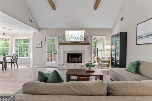 15 Stonewood Way, Sharpsburg, GA 30277 - living area with high vaulted ceiling, a chandelier, wood finished floors, beamed ceiling, and a brick fireplace