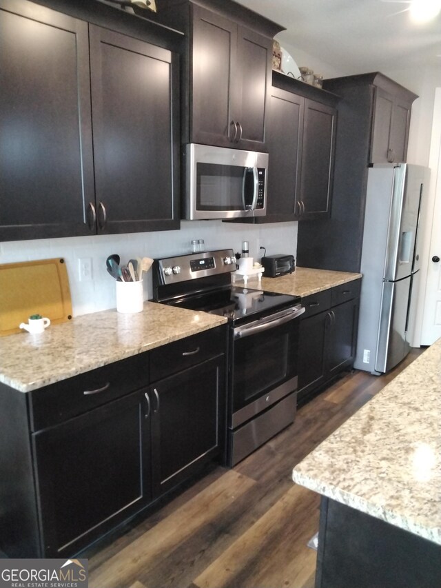211 Barnyard Way, Perry, GA 31069 - kitchen with stainless steel appliances, dark wood-style floors, and light stone countertops