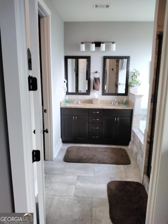 211 Barnyard Way, Perry, GA 31069 - bathroom featuring double vanity, tiled tub, and tile patterned floors