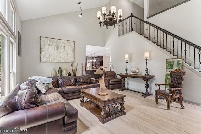 3835 Hickory Branch Trl, Suwanee, GA 30024 - living area featuring a chandelier, wood finished floors, stairway, healthy amount of natural light, and high vaulted ceiling