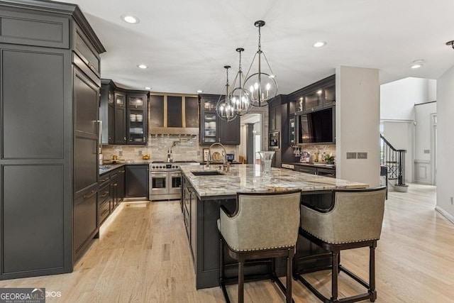 3835 Hickory Branch Trl, Suwanee, GA 30024 - kitchen featuring double oven range, backsplash, light stone counters, light wood-style floors, and recessed lighting