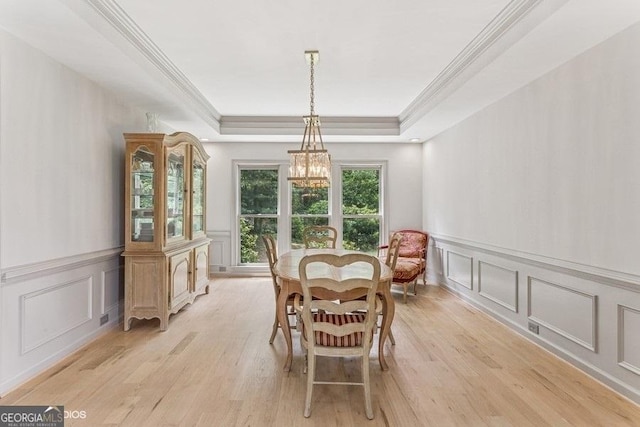 3835 Hickory Branch Trl, Suwanee, GA 30024 - dining room with a decorative wall, a raised ceiling, a chandelier, crown molding, and light wood-style flooring