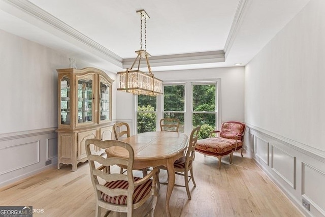 3835 Hickory Branch Trl, Suwanee, GA 30024 - dining space featuring a decorative wall, ornamental molding, light wood-type flooring, a raised ceiling, and a wainscoted wall
