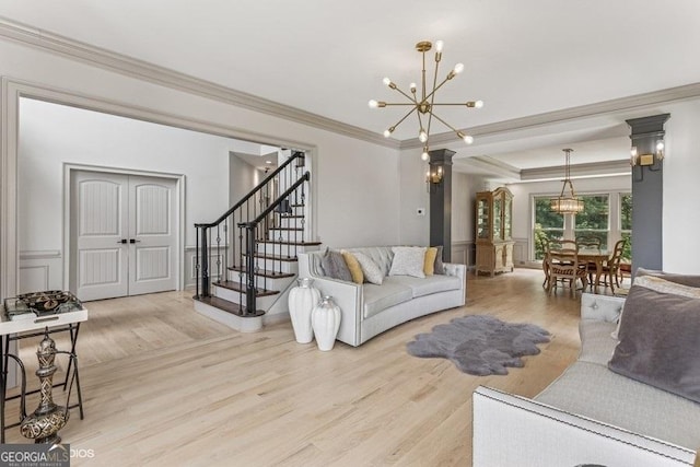 3835 Hickory Branch Trl, Suwanee, GA 30024 - living room featuring ornamental molding, a chandelier, light wood-style flooring, stairway, and a wainscoted wall
