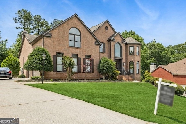 3835 Hickory Branch Trl, Suwanee, GA 30024 - view of front of property with a front yard, brick siding, concrete driveway, and a chimney