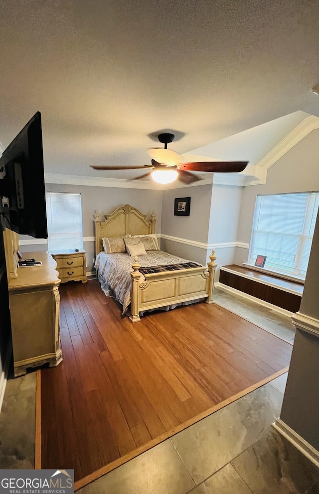 2481 Islands Hwy, Midway, GA 31320 - bedroom with multiple windows, a ceiling fan, vaulted ceiling, a textured ceiling, and wood-type flooring