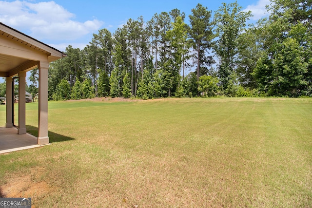 8041 Louis Dr, Locust Grove, GA 30248 - view of green lawn featuring a patio and view of wooded area