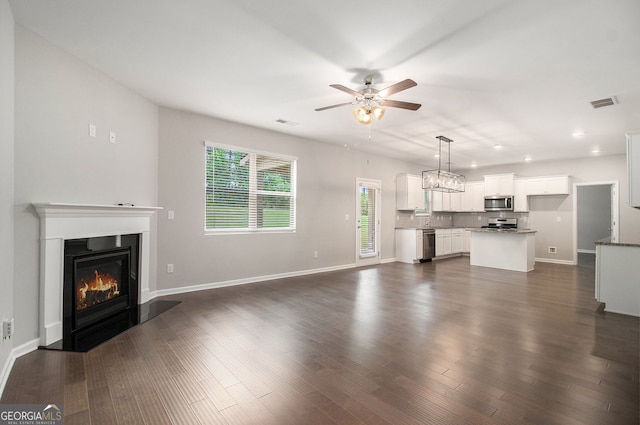 8041 Louis Dr, Locust Grove, GA 30248 - unfurnished living room with a ceiling fan, healthy amount of natural light, a glass covered fireplace, recessed lighting, and dark wood-style flooring