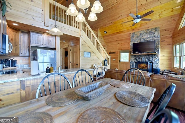 73 Rosiey Ln Unit 356, Blue Ridge, GA 30513 - dining area featuring stairway, a stone fireplace, wooden walls, a ceiling fan, and a chandelier