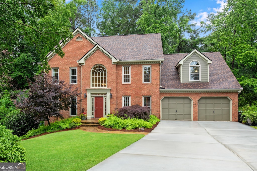 3915 Woolbridge Way, Marietta, GA 30062 - colonial home featuring driveway, a shingled roof, brick siding, a front lawn, and an attached garage
